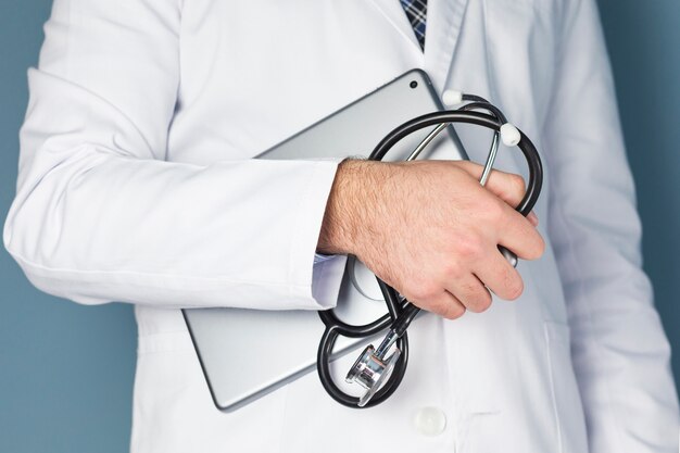 Close-up of a male doctor hand holding digital tablet and stethoscope