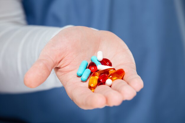 Close up of male doctor hand holding pills