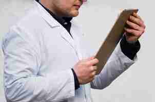 Free photo close-up of a male doctor's hand reading the medical report on clipboard