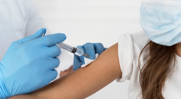 Free photo close-up of male doctor vaccinating a girl