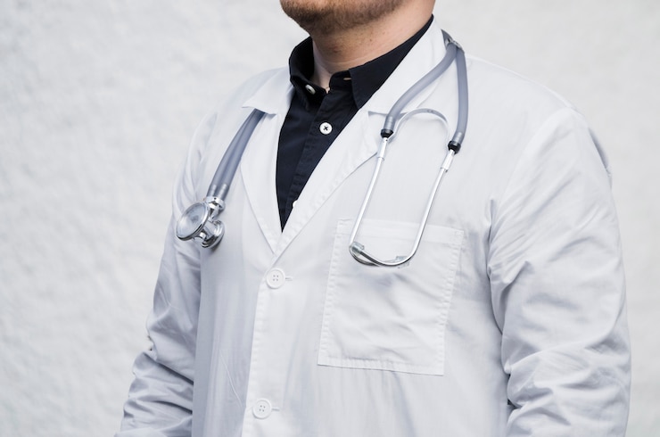 Free Photo close-up of a male doctor with stethoscope around his neck against white backdrop
