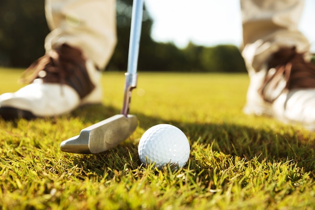 Close-up of male golfer teeing off