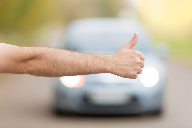 Close up of male hand hitchhiking