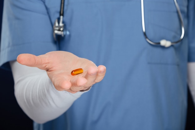 Close up of male hand holding medical capsule