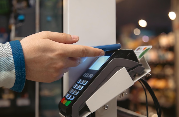 Free Photo close up of male hand holding smartphone in payment terminal