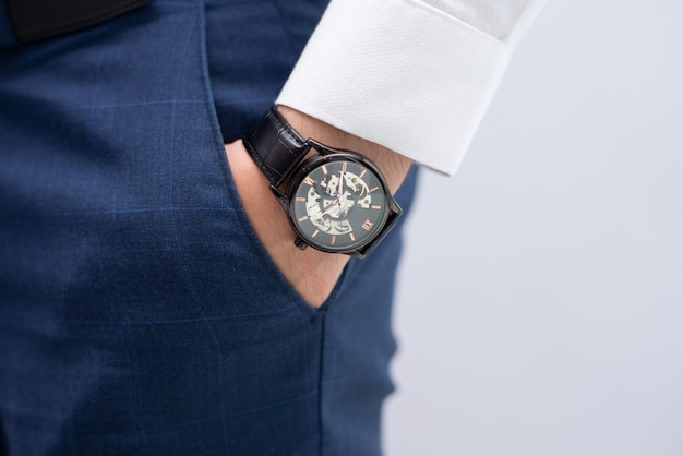 現代的なエレガントな腕時計とポケットの男性の手のクローズアップ