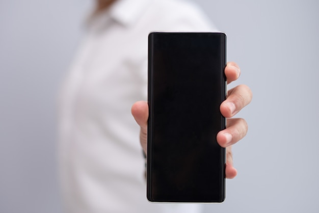 Close-up of male hand showing new model of smartphone