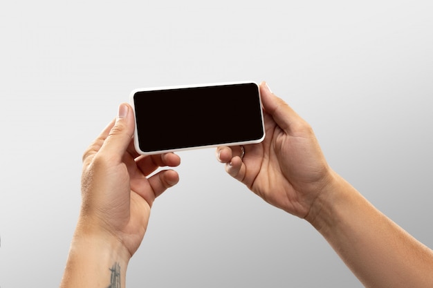 Close up male hands holding phone with blank screen during online watching of popular sport matches and championships all around world.