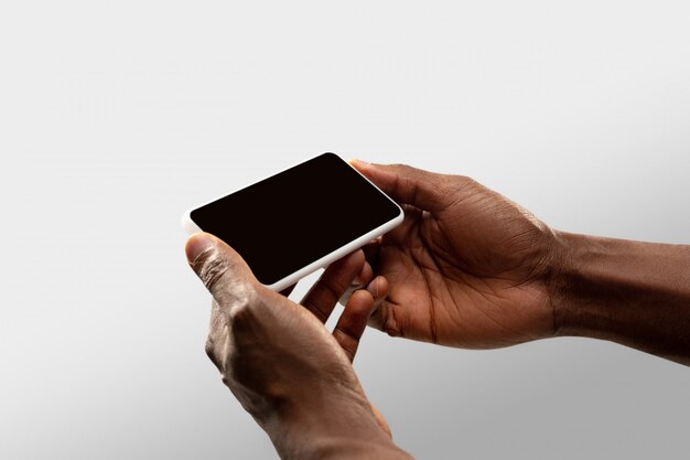 Close up male hands holding phone with blank screen during online watching of popular sport matches and championships all around world.