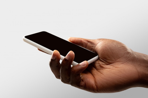 Close up male hands holding phone with blank screen during online watching of popular sport matches and championships all around world.