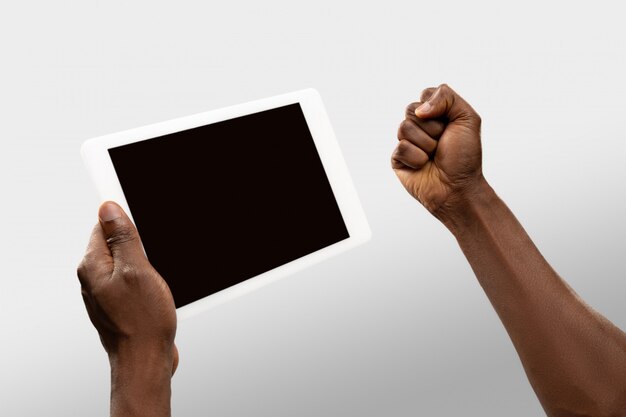 Close up male hands holding tablet with blank screen during online watching of popular sport matches and championships all around world.