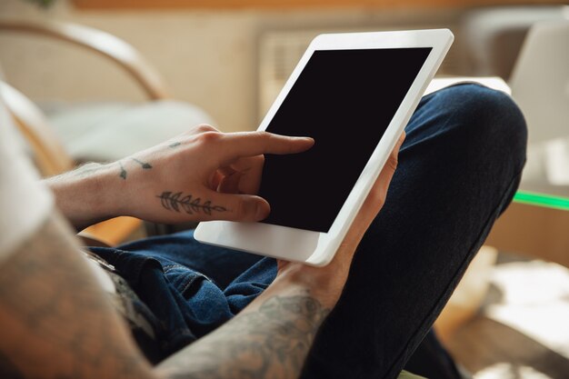 Close up of male hands using tablet with blank screen, copyspace.