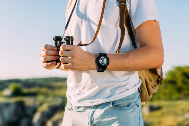 Close-up of male hiker holding binocular in his hand