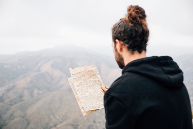 Free photo close-up of a male hiker reading the map