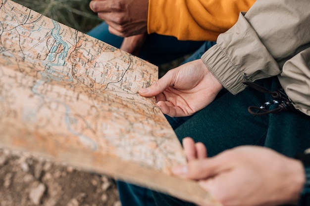 Foto gratuita primo piano della mano dell'escursionista maschio che tiene la mappa