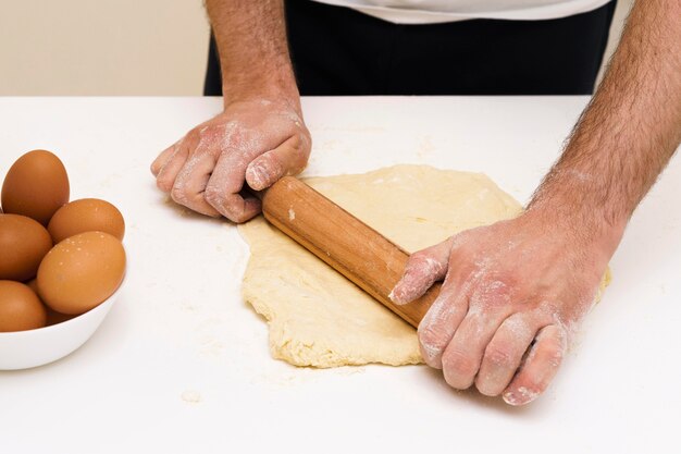 Close-up male making dough