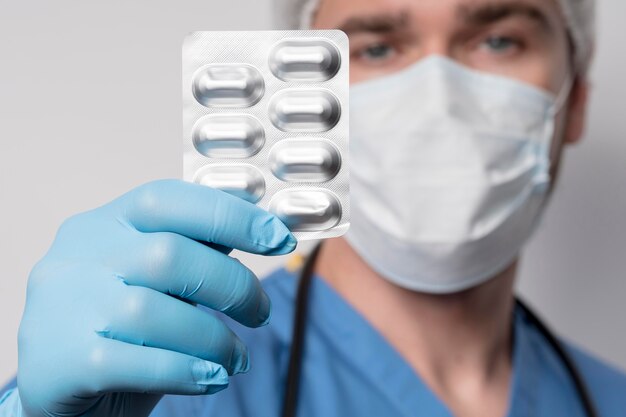 Close-up male nurse holding medical tablets