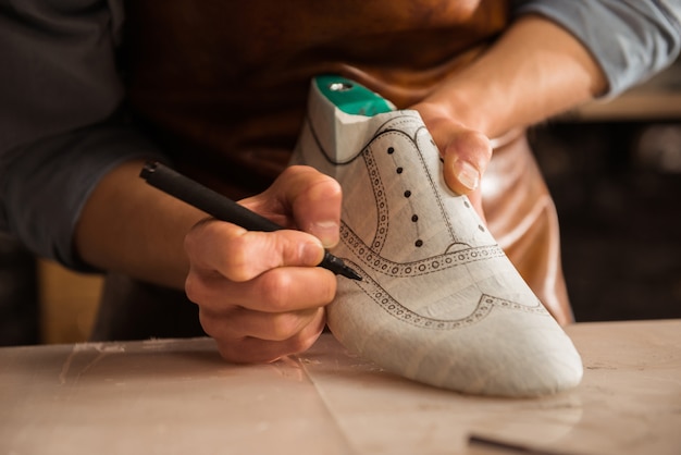 Free photo close up of a male shoemaker drawing design