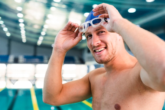 Free photo close-up male swimmer putting goggles