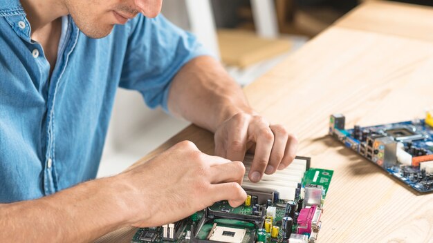 close-up of male technician assembling motherboard