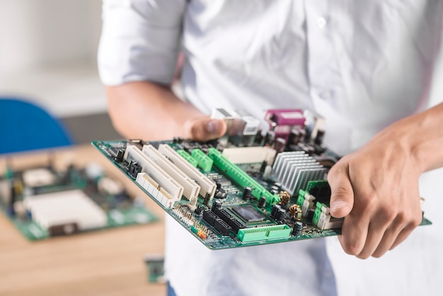 Primo piano della scheda madre del computer della tenuta del tecnico maschio