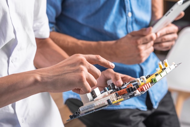 Close-up of male technician pointing at motherboard