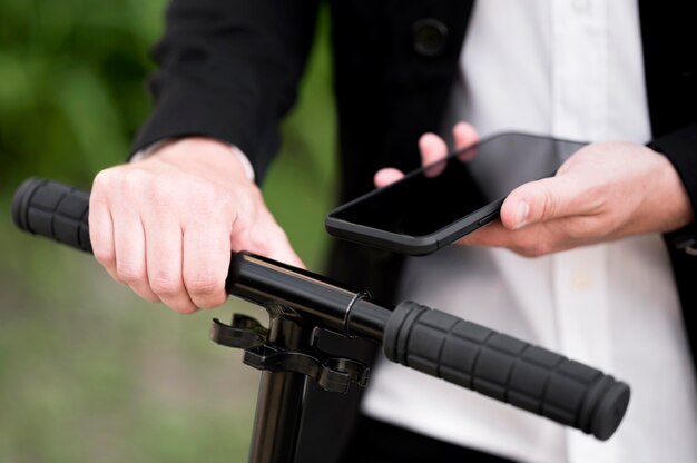 Close-up male unblocking scooter with mobile phone