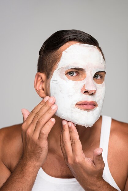 Close-up man applying face mask