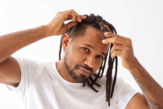 Free photo close up man applying hair treatment