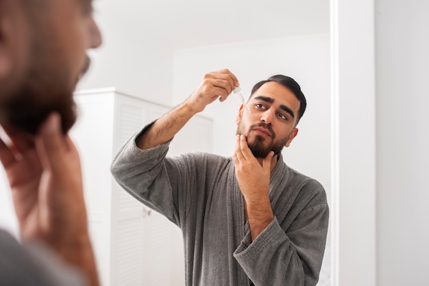 Close up man applying serum