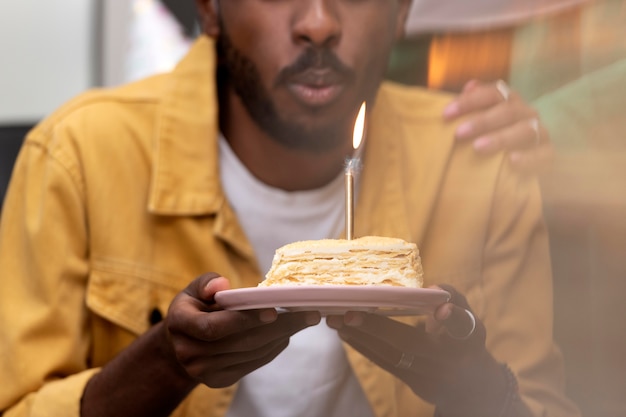 Free photo close up man blowing candle