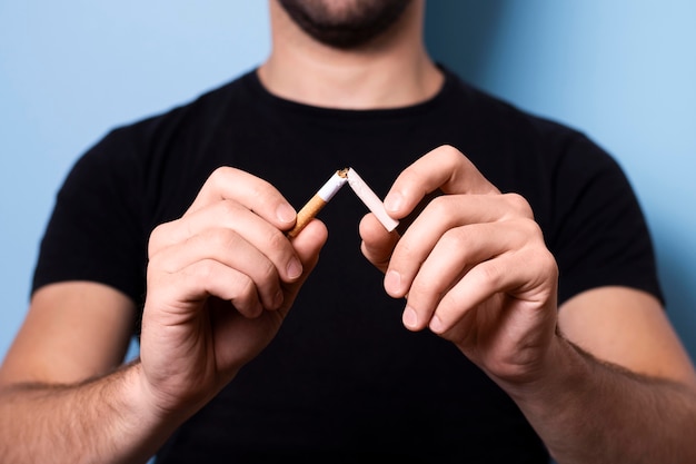 Free photo close-up man breaking cigarette