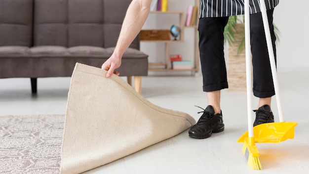 Close-up man brooming floor