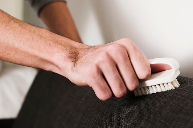 close up man brushing couch