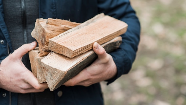 Close-up man carrying wood