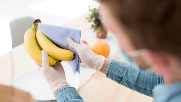 Close-up man cleaning bananas