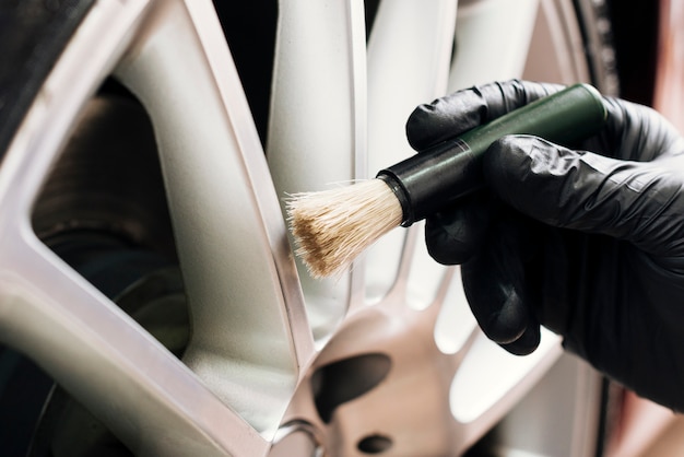 Free photo close up of man cleaning car rims