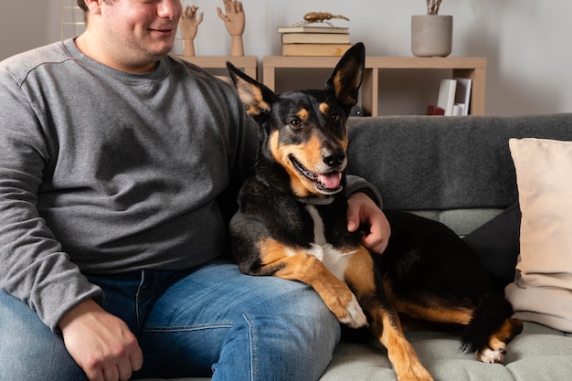 Крупным планом человек на диване с собакой