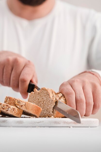 Close-up man cutting bread