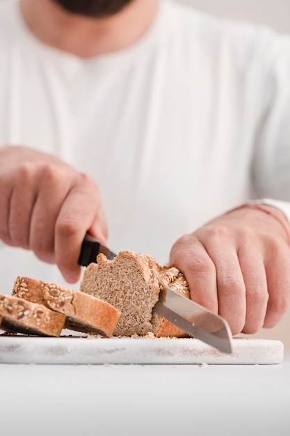 Close-up man cutting bread