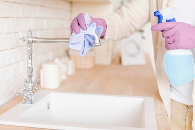 Close-up man disinfecting sink