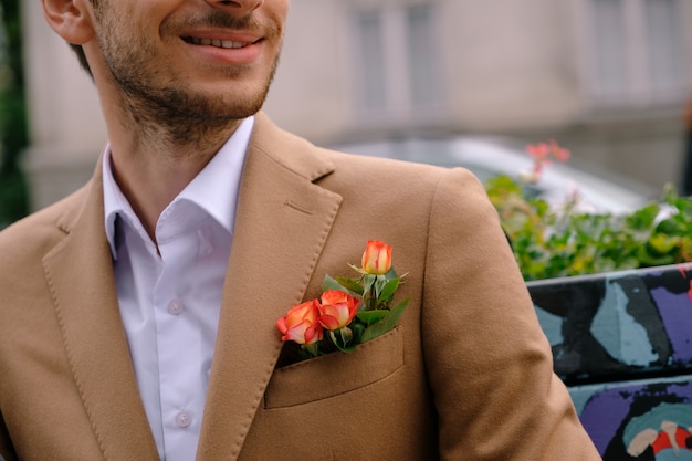 ポケットに3本のバラと上品なジャケットに身を包んだクローズアップ男