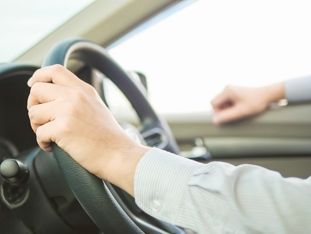 Close up of a man driving car using one hand, dangerous behavior