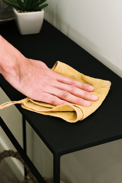 Close up man dusting table