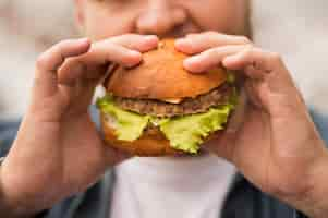 Free photo close-up man eating burger