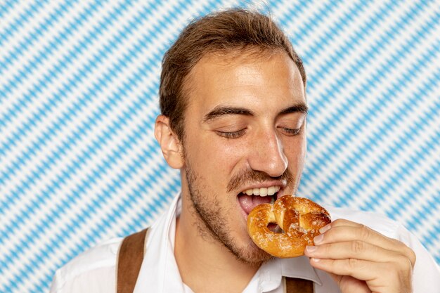 Close-up of man eating pretzel
