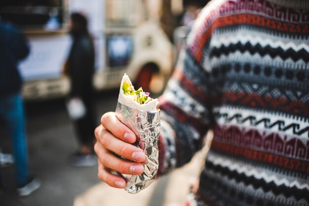 Close-up man eating shawarma