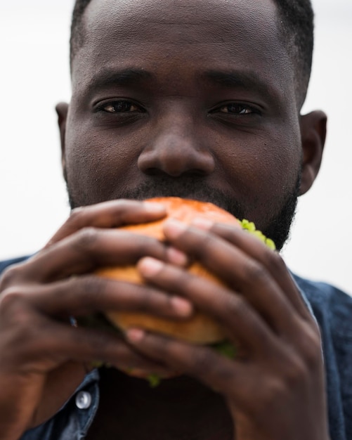 おいしいハンバーガーを食べるクローズアップの男