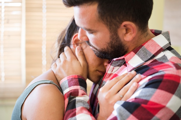 Close-up of a man embracing his wife