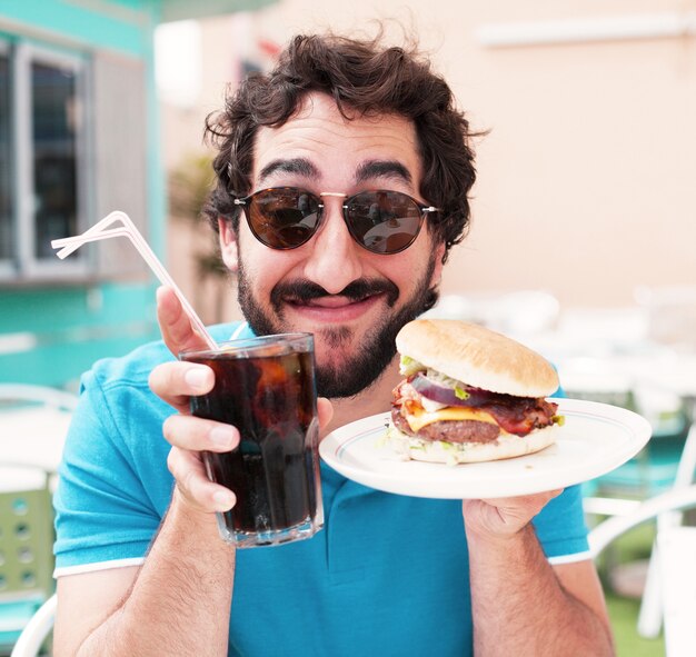 Close-up of man enjoying his burger and soft drink